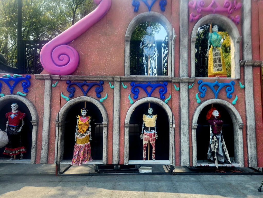 Wall of life-sized Dia De Los Muertos-style skeleton figurines at the entrance to Chapultepec Park in Mexico City